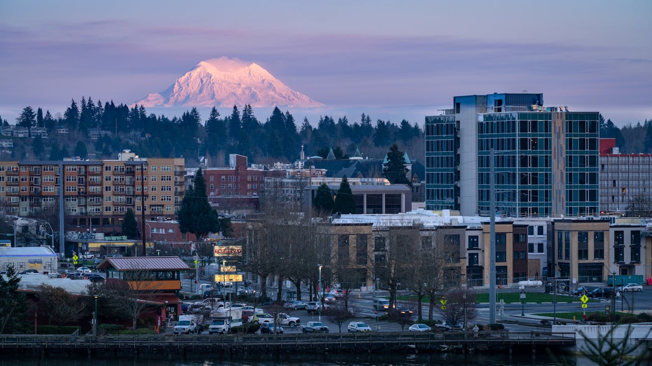 Olympia cityscape at dusk featuring Mount Rainier in the background.